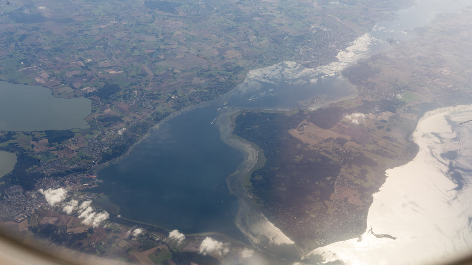 Luftfoto af Roskilde Fjord med kystlinje og lavvandede områder.